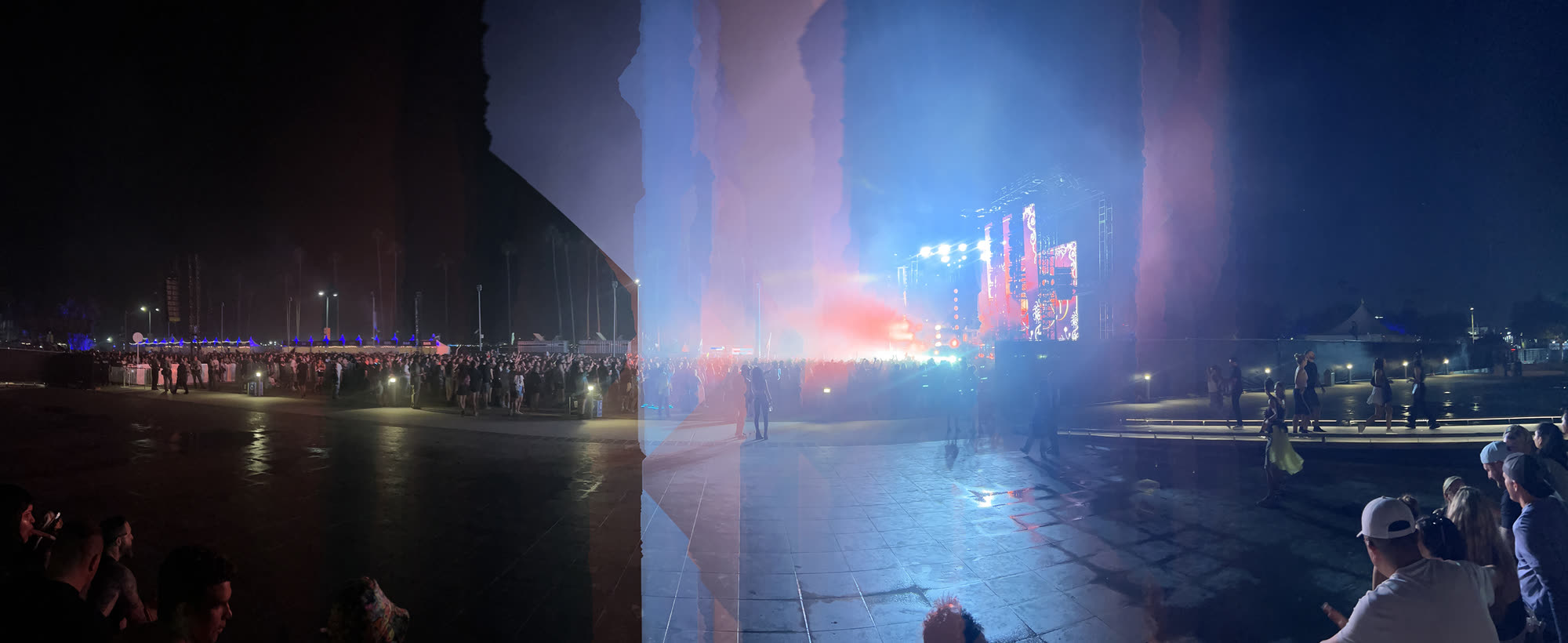 Blue and rose stage light dissolving into vertical veils, the crowd and plaza softened by the sweep.